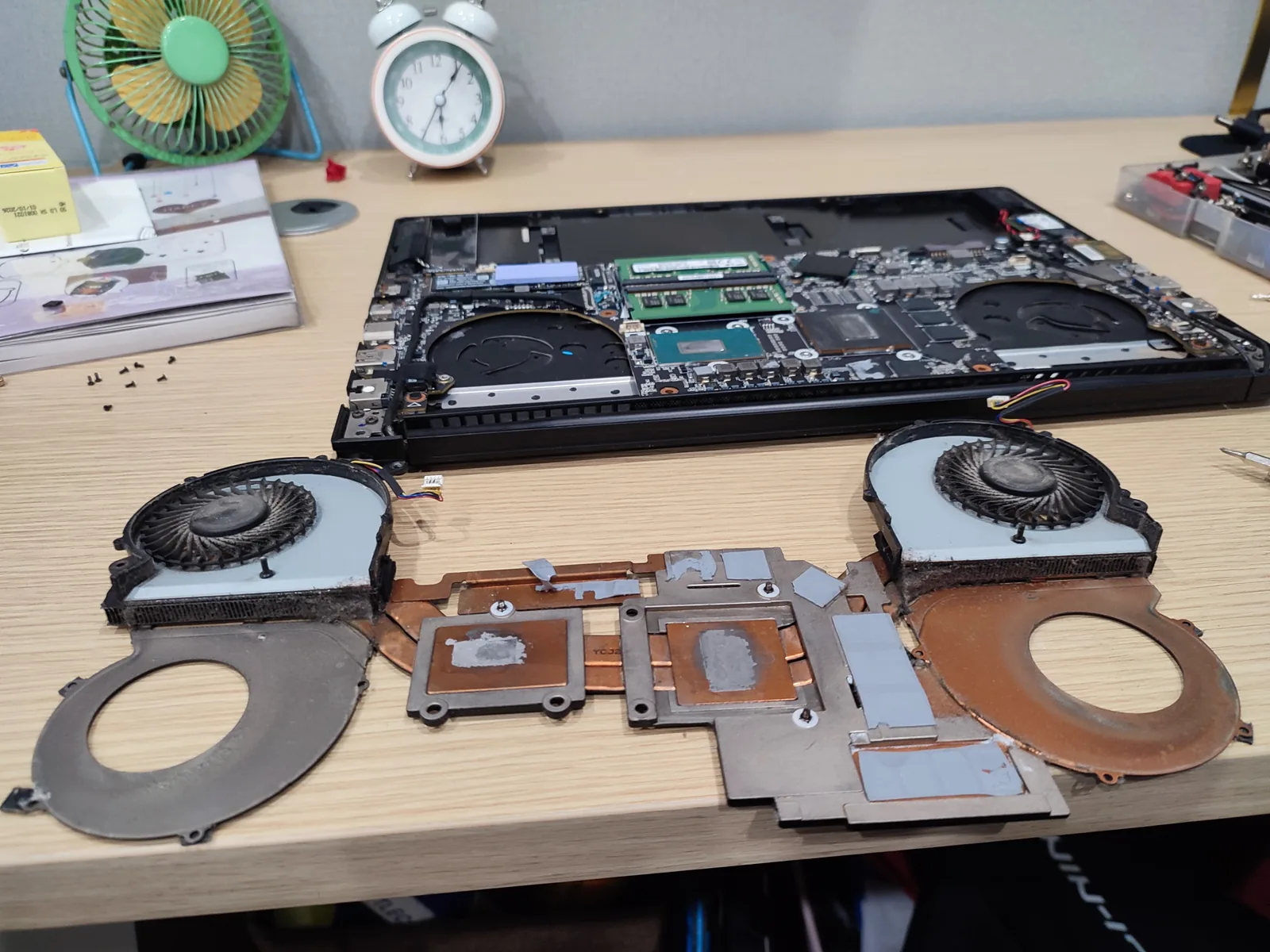 Laptop tháo rời, quạt và bộ tản nhiệt xếp ra bàn để vệ sinh